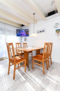 a dining room with a wooden table and chairs at Ferienhaus Deichliebe in Bensersiel