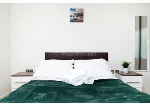 a bedroom with a green bed with two white pillows at Chic London 1 bedroom flat in London