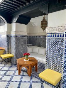 Cette chambre comprend un lit, une table et des chaises. dans l'établissement Riad Zouhour, à Marrakech