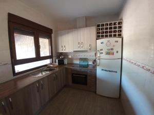 cocina con nevera blanca y ventana en Villa Nieves Bonillo, en Villarrobledo