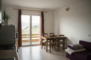a living room with a table and chairs and a balcony at House Baglija in Lumbarda