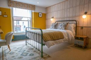 Schlafzimmer mit einem Bett und einem Fenster in der Unterkunft The Sheep and Penguin in Wells
