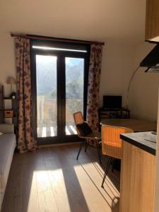 ein Wohnzimmer mit einem großen Fenster mit Aussicht in der Unterkunft Studio avec Balcon Pra chauvet in Uvernet