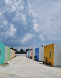 una fila de edificios coloridos con un cielo nublado en Klong Zand Resort en Rayong