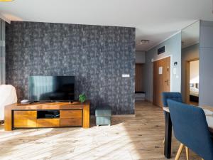 a living room with a flat screen tv on a wall at Beskid Apartment in Szczyrk