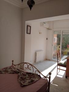 a bedroom with a bed and a large window at Mia casa in La Goulette
