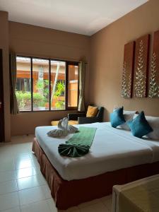 a bedroom with a large bed with blue pillows at Phuket Siam Villas - SHA PLUS in Chalong 