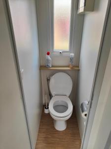 a small bathroom with a toilet with a window at Mobil-home in Valras-Plage