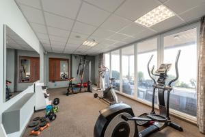 a gym with treadmills and ellipticals in a room with windows at Hotel Glamour in Kaluža +47 photos