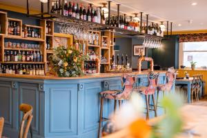 bar z niebieskimi szafkami i stołkami barowymi w obiekcie The Sheep and Penguin w mieście Wells