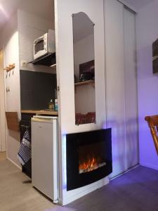 a living room with a fireplace in a kitchen at Les pieds presque dans l'eau in Leucate