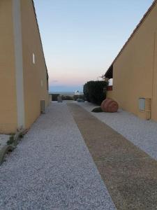 an empty walkway between two buildings next to the ocean at Les pieds presque dans l'eau in Leucate +5 photos