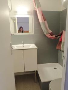 a woman is taking a picture of a bathroom at Les pieds presque dans l'eau in Leucate