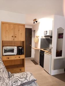 a small kitchen with a microwave and a stove at Les pieds presque dans l'eau in Leucate