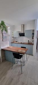 Monolocale Splendida casa vacanze in Tenerife del Sur Casa Mimì في أرونا: مطبخ كبير مع طاولة وكراسي خشبية