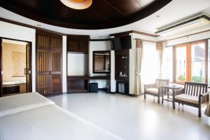 1 dormitorio con 1 cama, 2 sillas y mesa en Golden Beach Resort, en Ao Nang Beach