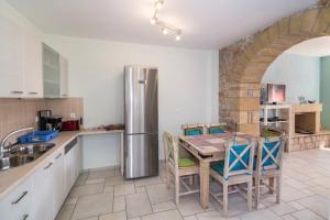 a kitchen with a table and a stainless steel refrigerator at Villa Lakonia in Stoupa in Stoupa