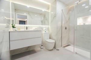 La salle de bains blanche est pourvue d'une douche et de toilettes. dans l'établissement Modern and luxurious -3 Bdr 2Bth- Pastor y Landero, à Séville