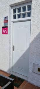 eine weiße Tür an der Seite eines Gebäudes in der Unterkunft Monolocale Splendida casa vacanze in Tenerife del Sur Casa Mimì in Arona