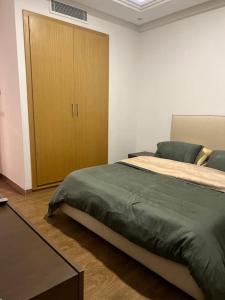 sypialnia z dużym łóżkiem i drewnianą szafką w obiekcie Appartement luxueux w mieście Tunis