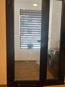 a door to a bathroom with a window with a washing machine at Appartement luxueux in Tunis