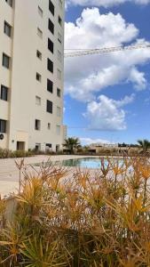widok na dwa wysokie budynki i basen w obiekcie Appartement luxueux w mieście Tunis