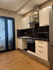 a kitchen with white cabinets and a black stove top oven at Appartement luxueux in Tunis
