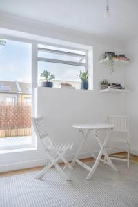 a white table and a chair in a room with a window at Stylish & Homely 1BD Flat - Walthamstow! in London