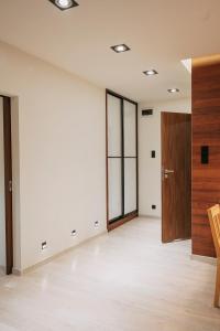 Habitación vacía con puerta de madera y suelo de madera. en Niron Apartament Kapucyńska en Piła