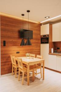 uma cozinha e sala de jantar com uma parede de madeira em Niron Apartament Kapucyńska em Pila