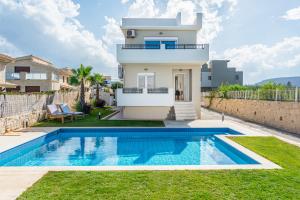 a villa with a swimming pool in front of a house at Villa Sophia-Elpis in Hersonissos