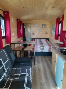 een kleine kamer met een bed en een tafel en stoelen bij L'Insolite de Nathcy in Thiel-sur-Acolin