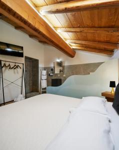 uma grande cama branca num quarto com tectos em madeira em Agriturismo Cascina Mirandola em Como