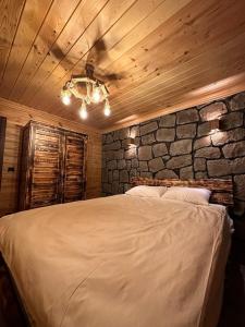 a bedroom with a large bed with a stone wall at VİRA TAŞ KONAK in Trabzon