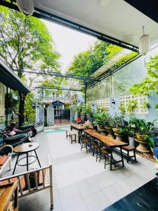 un patio con mesas, sillas y plantas en SHARK HOSTEL en Hue