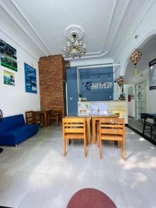 comedor con sofá azul, mesa y sillas en SHARK HOSTEL en Hue