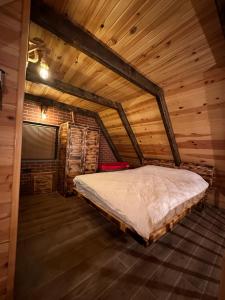 a bedroom in a log cabin with a bed at VİRA TAŞ KONAK in Trabzon