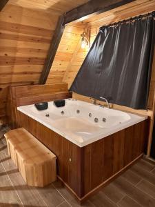 une baignoire jacuzzi dans une pièce en bois avec rideau dans l'établissement VİRA TAŞ KONAK, à Trabzon