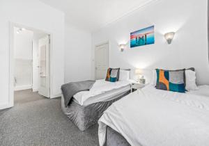 - 2 lits dans une chambre aux murs blancs dans l'établissement Elmbank Apartment by Klass Living Bellshill, à Bellshill