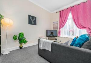 - un salon avec un canapé et une fenêtre dans l'établissement Elmbank Apartment by Klass Living Bellshill, à Bellshill