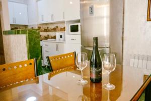 a bottle of wine sitting on a table with two wine glasses at Ekaterine's Apartments in Batumi