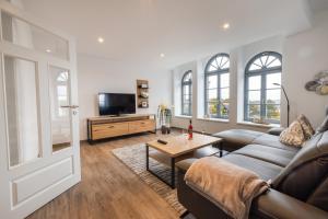 uma sala de estar com um sofá e uma televisão em Bed & Bahn Seesen em Seesen