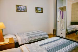 a small room with two beds and a mirror at Ekaterine's Apartments in Batumi