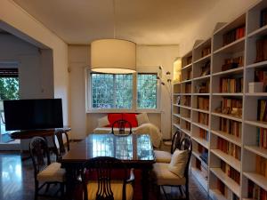 a living room with a table and book shelves at Appartamento con giardino in zona Ponte Milvio e Stadio Olimpico in Rome