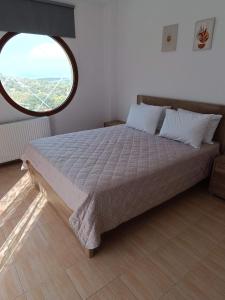 a bedroom with a large bed with a large window at ΑΡΧΟΝΤΙΚΟ ΜΑΝΤΕΙΟ in Manteio