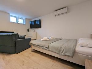 una camera con letto, divano e TV di Yellow Pup in Maksimir a Zagabria