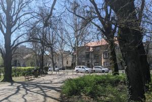 un parco con auto parcheggiate, alberi ed edifici di Yellow Pup in Maksimir a Zagabria