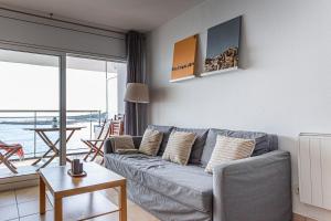 un soggiorno con divano grigio e balcone di INMUEBLE DE CATEGORIA. Wifi FREE a L'Escala