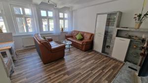 een woonkamer met 2 stoelen en een tafel bij Manu's Appartements in Goslar
