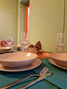 聖傑可莫的住宿－WH-Bilocale Green Roburent，一张桌子上放有盘子和酒杯